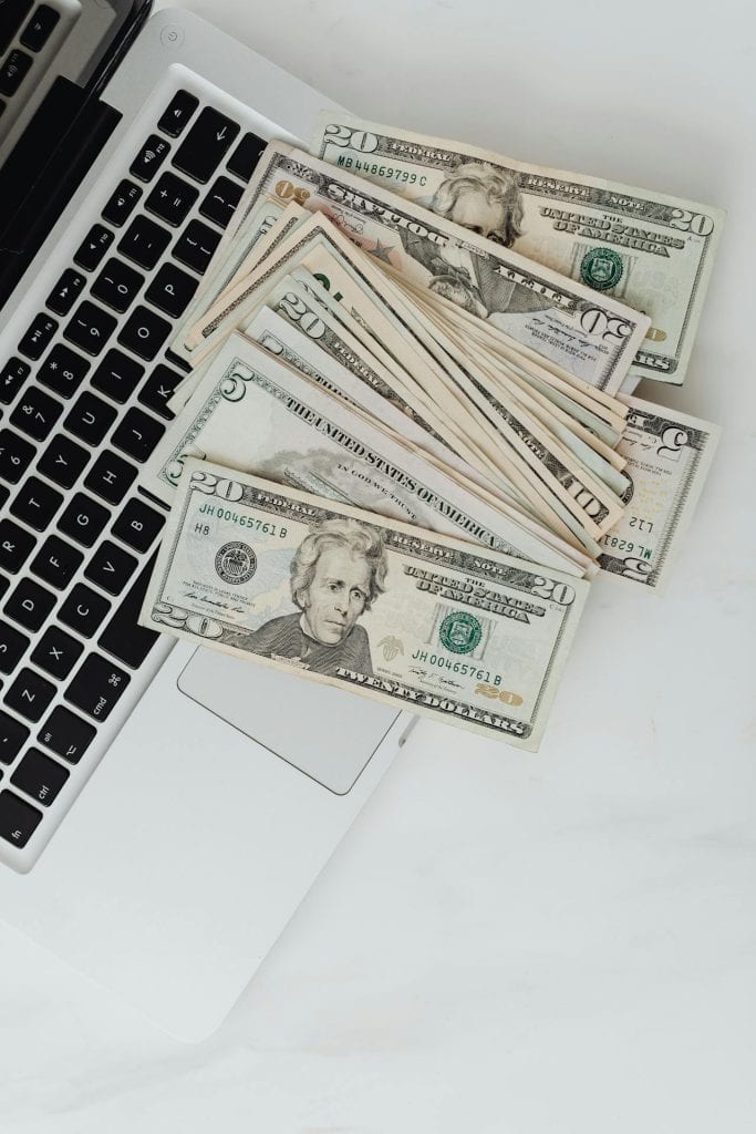 Financial planning with cash and laptop for insurance services.