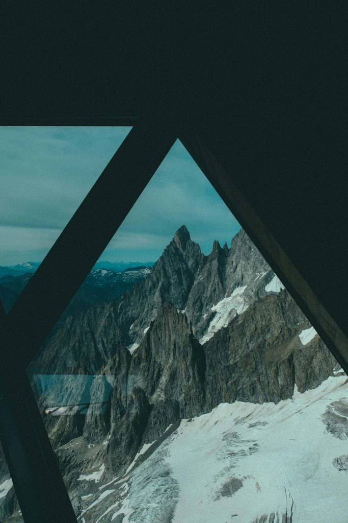 An image of a mountain seen through a glass A-frame