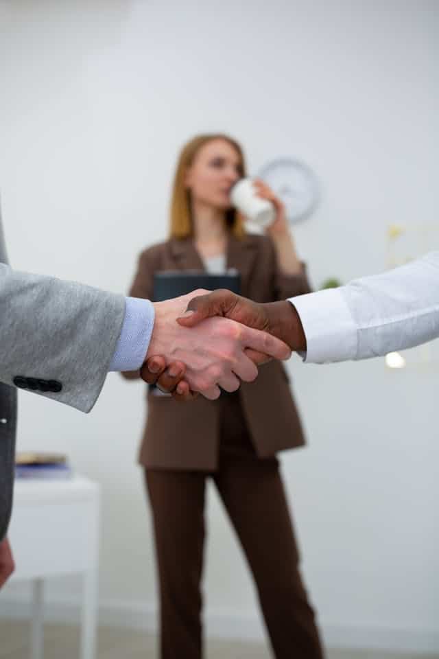 Business handshake symbolizing trust and partnership in insurance services.
